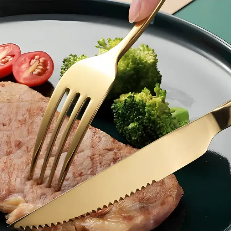 jogo-de-talheres-dourado-em-inox-modernize-foto-pessoa-cortando-carne-com-garfo-e-faca